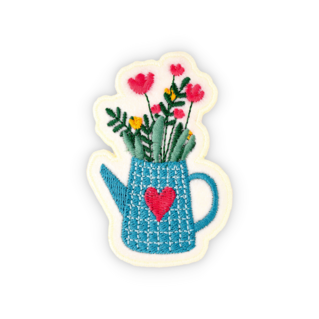 Geborduurde badge op vilt. Bloemen in de gieter. 